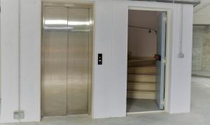 - une porte coulissante en verre dans une chambre avec des escaliers dans l'établissement Dimora Punta Azzurra, à Polignano a Mare