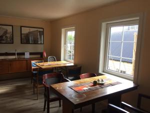 ein Esszimmer mit zwei Tischen und einem Fenster in der Unterkunft Holiday in the former fishing factory Arntzen-brygga in Nyksund + 12 Fotos