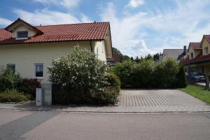 una casa blanca con techo rojo en una calle en Ferienhaus Lindelburg en Schwarzenbruck