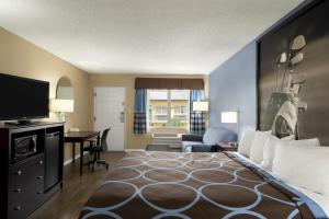 Habitación de hotel con cama grande y escritorio. en Super 8 by Wyndham Valdosta GA I-75, en Valdosta