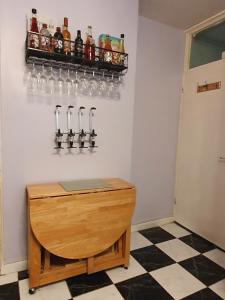 a wooden table topped with a bottle of beer next to a refrigerator at Exclusive rooms in London