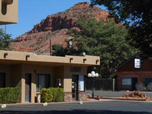 a building with a mountain in the background at Redrock Country Inn in Kanab
