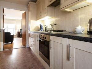 a kitchen with white cabinets and a black counter top at 20/5 Timber Bush in Edinburgh