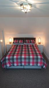a bedroom with a bed with two lamps on it at Seaforth Cottage. in Nairn