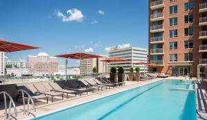 a swimming pool with chairs and umbrellas on a building at National at Pentagon in Arlington