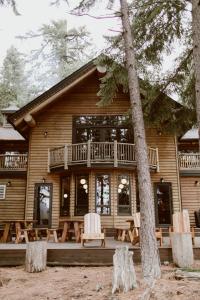 a log cabin with a deck and tables and chairs at The Suttle Lodge & Boathouse in Camp Sherman