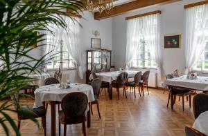 a dining room with tables and chairs and windows at Dwór w Bychowie in Bychowo