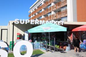 a store with a blue umbrella in front of a building at PARADISO 308-309 Private Studios Nessebar in Nesebar