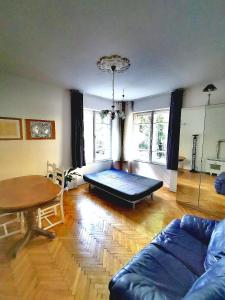 ein Wohnzimmer mit einem Sofa und einem Tisch in der Unterkunft ROMANTIC studio in 12th district of Budapest, close to MOM Park in Budapest