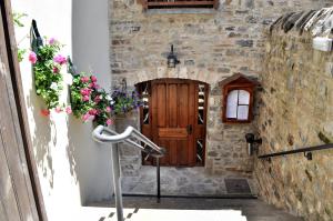 een stenen gebouw met een houten deur en bloemen bij Casa Montse in Torla