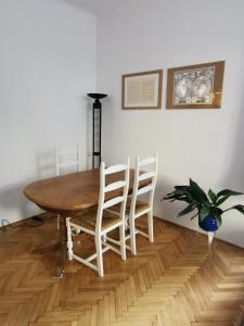 einem Esstisch mit 4 Stühlen und einer Pflanze in der Unterkunft ROMANTIC studio in 12th district of Budapest, close to MOM Park in Budapest