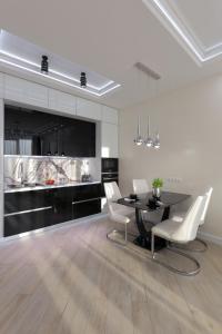 基輔的住宿－Black&White Apartment in Smart Plaza，一间用餐室,配有黑桌和白色椅子