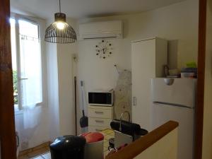 a kitchen with a white refrigerator and a microwave at 6 rue de la tourraque in Antibes