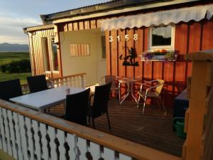 a house with a deck with a table and chairs at Midnattsolveien 3158,Sommarhusstrand Laukvik Lofoten Norway in Laukvik