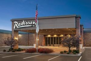 a building with an american flag in front of it at Radisson Hotel and Conference Center Fond du Lac in Fond du Lac