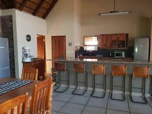 a kitchen with a bar with chairs and a counter top at Kubu Khaya Mabalingwe in Mabula