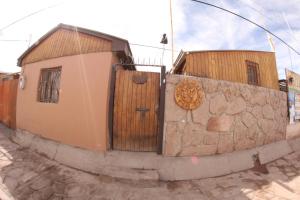 a building with a wooden door on a stone wall at Hostal Mamatierra in San Pedro de Atacama