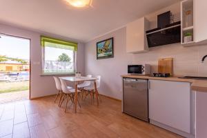 a kitchen and dining room with a table and chairs at Domki przy zalewie in Kamień Pomorski