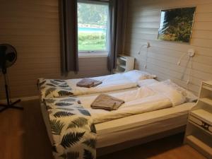 a bedroom with a large bed with a window at Midnattsolveien 3158,Sommarhusstrand in Laukvik