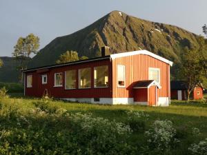 a red house with a mountain in the background at Midnattsolveien 3158,Sommarhusstrand Laukvik Lofoten Norway in Laukvik