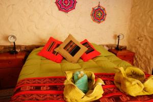a bed with a blanket and pillows on it at Hostal Mamatierra in San Pedro de Atacama