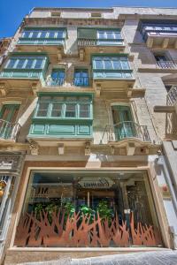 um edifício alto com uma frente de loja com janelas em Palazzo Rosaria Boutique Hotel em Valletta