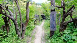 a dirt trail through a forest with a sign on a pole at Yamazatonoiori Soene in Takayama