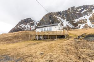 ein Haus auf einem Hügel vor einem Berg in der Unterkunft Eagle Point Lofoten in Eggum