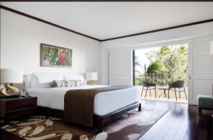 um quarto com uma cama grande e uma varanda em Lotus Honolulu at Diamond Head em Honolulu