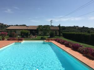 una grande piscina blu di fronte a una casa di Agriturismo "Le Rondinelle" a Valiano