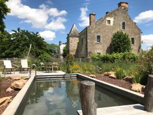 una vieja casa de piedra con una piscina frente a ella en Manoir de Jouralem, en Blaison