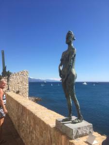 a statue of a man standing on a wall near the water at 6 rue de la tourraque in Antibes