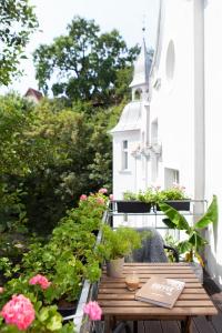 a wooden table on a balcony with flowers and a church at King Sobieski Apartments by OneApartments in Sopot