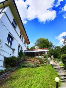 a house with a grassy yard next to a building at Ferienwohnung Albstadt Panorama in Albstadt