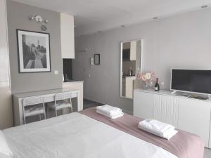 a white bedroom with a bed and a tv at Penthouse “Sky 16” Studio Apartment in Zagreb