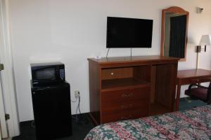 una habitación de hotel con TV en la parte superior de un tocador en Nationwide 9 Inn, en Wynne