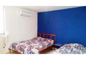 2 camas en una habitación con paredes azules en Edificio Playa - Vista al Mar, en Santa Marta