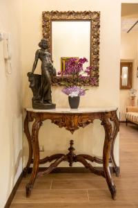 a table with a statue on it in front of a mirror at Kings Home In Rome in Rome