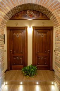 two wooden doors in a hallway with a plant at Kings Home In Rome in Rome