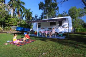 a group of people sitting on a blanket in front of a trailer at Aurora Kakadu Lodge in Jabiru