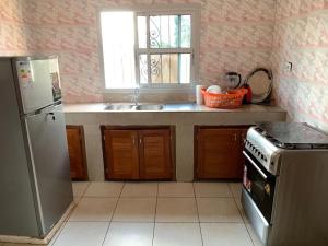 a kitchen with a refrigerator and a sink at Villa contemporaine in Yaoundé