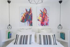 two beds in a room with two paintings of horses at JUNIORSUITEB&B in Capri +6 photos