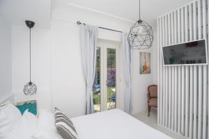 a white bedroom with a bed and a window at JUNIORSUITEB&B in Capri