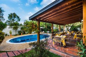an outdoor patio with a swimming pool and a deck at Hotel Portales Del Campestre in Medellín