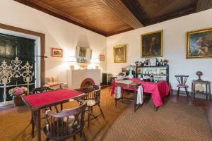 a living room with tables and chairs and a fireplace at Quinta do Valdalágea in Peso da Régua