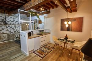 a kitchen with a table and a dining room at Lofts amantes de Toledo -LOFT COBERTIZO in Toledo