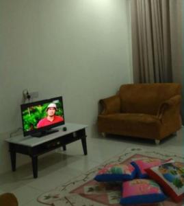 - un salon avec une télévision et un canapé dans l'établissement Dais Homestay Ipoh, à Ipoh