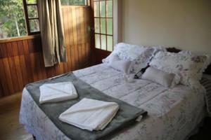 a bed with a tray on it in a bedroom at Chalés Luz da Montanha in Núcleo Mauá