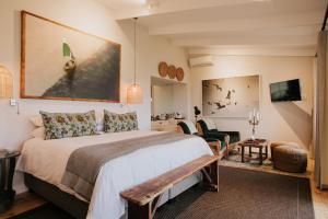 a hotel room with a large bed and a painting on the wall at Emily Moon River Lodge in Plettenberg Bay