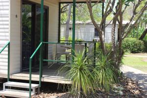 a screened porch with green railings on a house at Aurora Kakadu Lodge in Jabiru